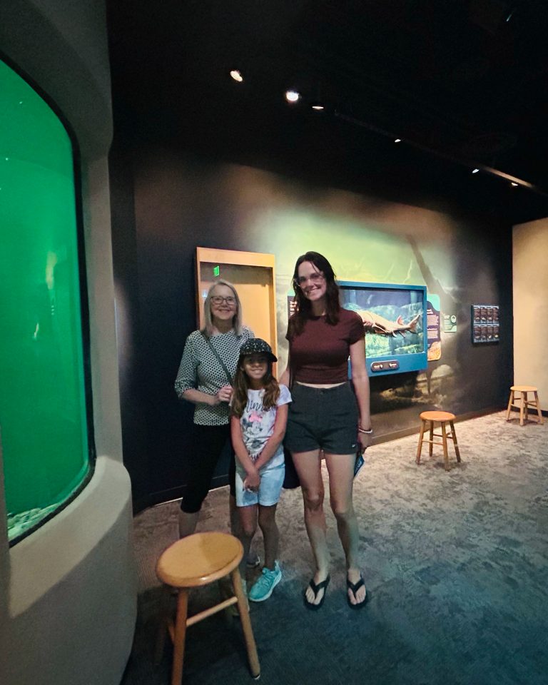 A family posing next to ECHO's newly refurbished salmon and trout tank.